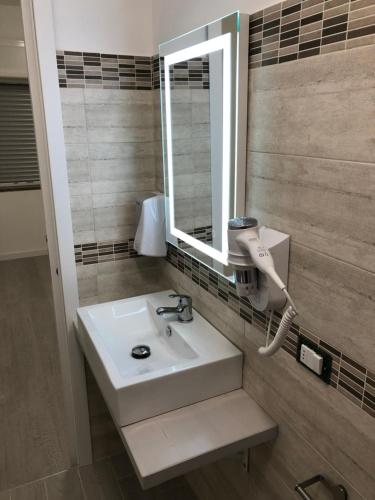 uma casa de banho com um lavatório e um espelho em B&B Le Palme em Diamante