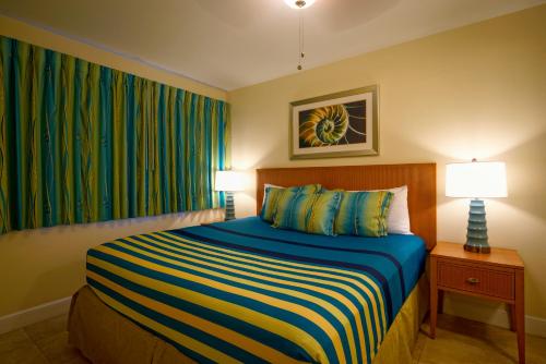 a bedroom with a bed and two lamps and a window at La Costa Beach Club in Pompano Beach