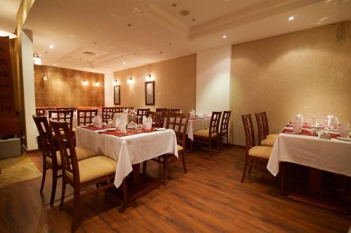 a dining room with tables and chairs with white tablecloths at Hala Hotel & Aqua Park in Bissau