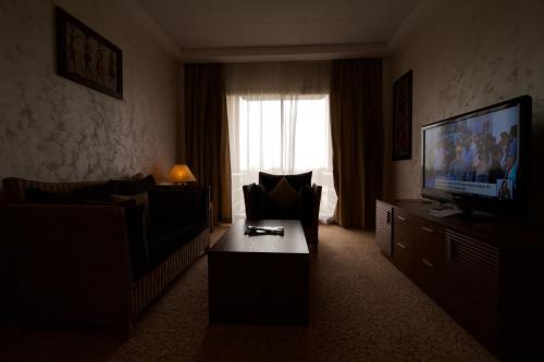 a living room with a couch and a television at Hala Hotel & Aqua Park in Bissau
