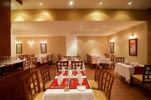 a restaurant with tables and chairs with white tablecloths at Hala Hotel & Aqua Park in Bissau