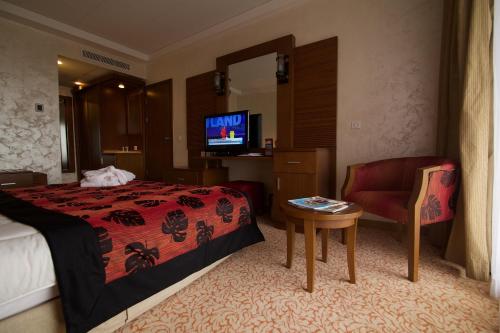 a hotel room with a bed and a chair at Hala Hotel & Aqua Park in Bissau