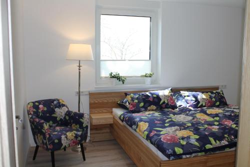 ein Schlafzimmer mit einem Bett, einem Stuhl und einem Fenster in der Unterkunft Fewo BELVEDERE- R-Auszeit in Bad Wildungen mit eigener Sauna in Bad Wildungen