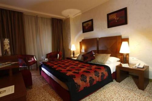 a hotel room with a large bed and a desk at Hala Hotel & Aqua Park in Bissau