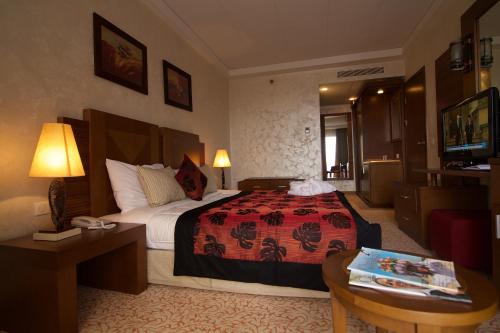 a hotel room with a large bed and a table at Hala Hotel & Aqua Park in Bissau