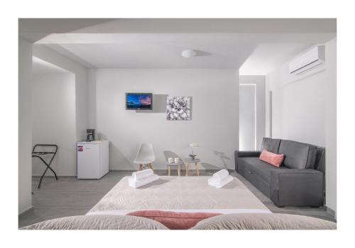 a white living room with a couch at Golden Sunlight Hotel by Estia in Gouves
