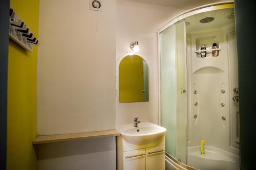 a bathroom with a sink and a shower at Timemachine Apartment in Valmiera
