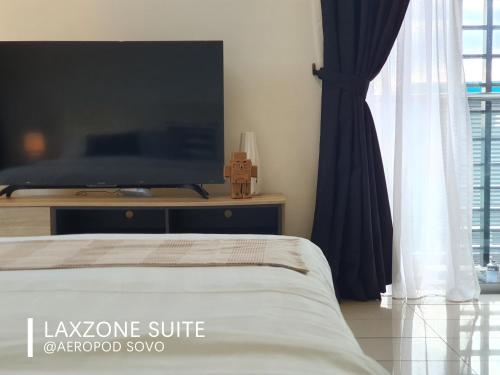 a bedroom with a bed and a large tv at Aeropod Sovo Kota Kinabalu By LAXZONE in Kota Kinabalu