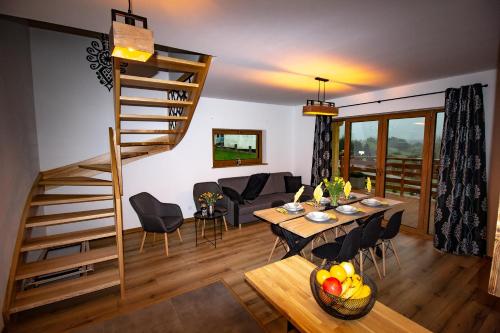 - un salon avec une table et un escalier en colimaçon dans l'établissement EM Gorce Resort, à Waksmund