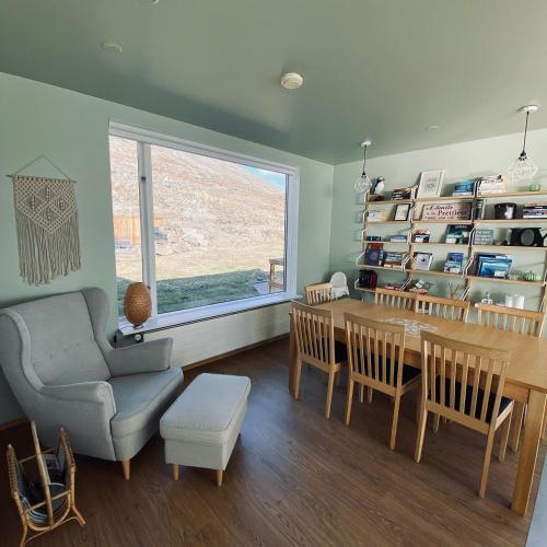 a living room with a table and a chair at Guesthouse Stekkaból in Patreksfjörður