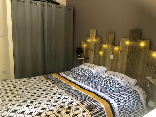 a bedroom with a bed with a wooden head board at Cottage piscine intérieure31degrés ZOO LA FLECHE24H du Mans in Clermont-Créans