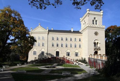 a large white building with a fountain in front of it at Hotel & Motorest V Údolí Zlatého potoka in Blšany