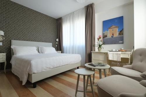 a bedroom with a bed and a chair and a table at Hotel Portavaldera in Peccioli