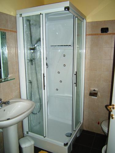 a shower with a glass door next to a sink at Hotel Empire Resort in Iseo