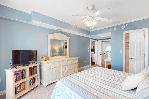 Schlafzimmer mit einem Bett, einem TV und einem Deckenventilator in der Unterkunft Adagio in Ocean City