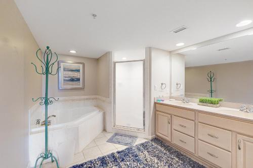 een badkamer met een bad, een wastafel en een douche bij Adagio in Ocean City
