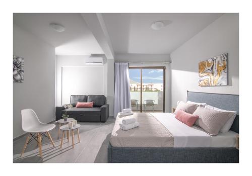 a bedroom with a king sized bed and a couch at Golden Sunlight Hotel by Estia in Gouves