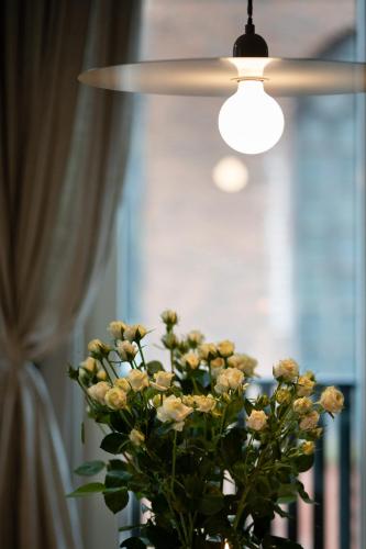 a bouquet of flowers in a vase under a ceiling fan at Redstone Apartments in Rīga