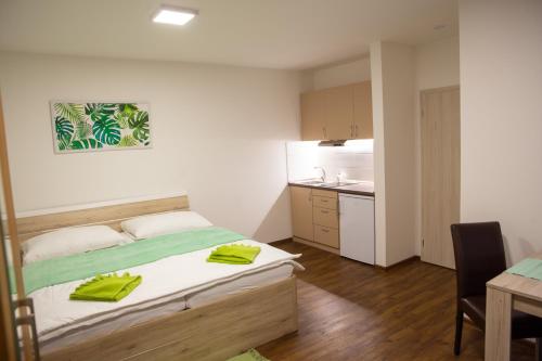 um quarto com uma cama com toalhas amarelas em Apartmány AAALIPNO em Lipno nad Vltavou
