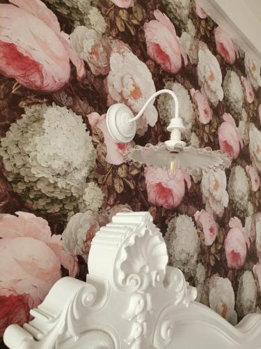 a room with pink flowers on a wall at La Tannerie de Montreuil in Montreuil-sur-Mer