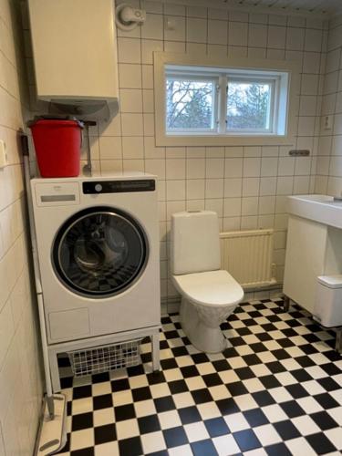 a bathroom with a washing machine and a toilet at Lillhuset Norr Sälens By in Sälen