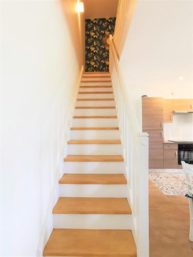 a staircase in a house with white walls and wooden floors at Gîte Ty coz'y in Québriac