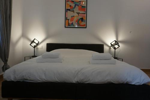 a bedroom with a large white bed with two lamps at Exarcheia House in Athens