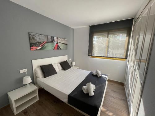 Un dormitorio con una cama grande y una ventana en For a Stay Catalunya 92, en Salou