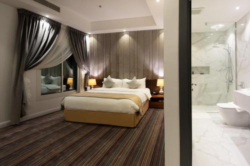 a bedroom with a large bed and a bathroom at Beach Time Villas Hotel in Jeddah