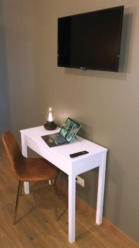a white desk with a laptop on it with a chair at Hotel Rural Solar das Arcadas in Ponte de Lima