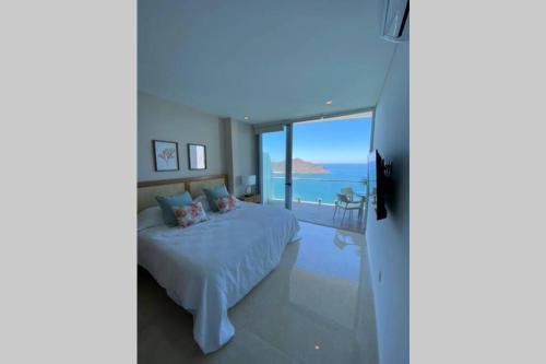 a bedroom with a bed and a view of the ocean at Camino al Mar. Exclusivo depa con vista al mar in Mazatlán