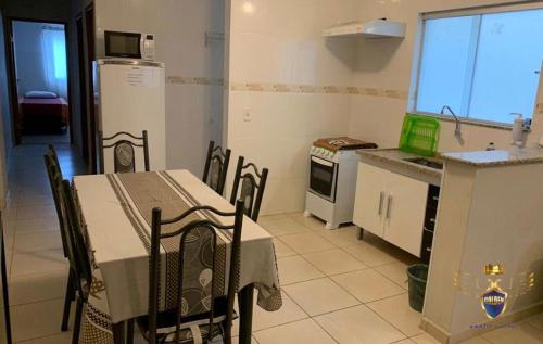 eine Küche mit einem Tisch und Stühlen sowie einem Kühlschrank in der Unterkunft Golden Apart Hotel in Aparecida