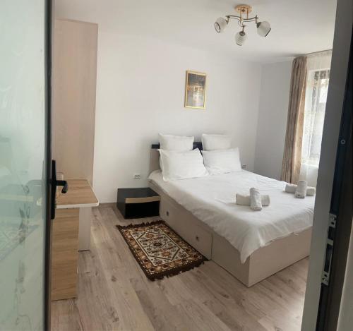 a bedroom with a bed with white sheets and white pillows at Casa Bianca Oncesti in Onceşti