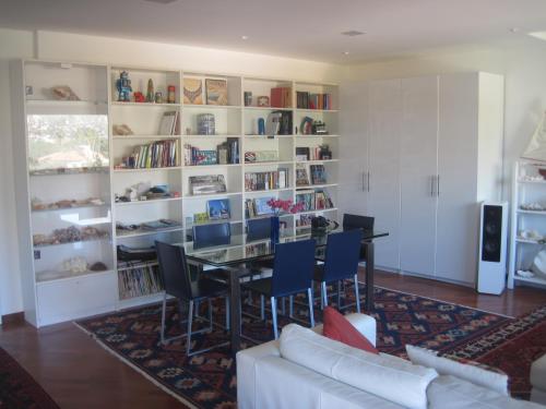 a living room with a dining room table and bookshelves at Mondello Luxury Apartment on the Beach in Mondello