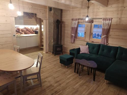 a living room with a green couch and a table at Beskidzka Ostoja - Miejsce z duszą in Ustroń