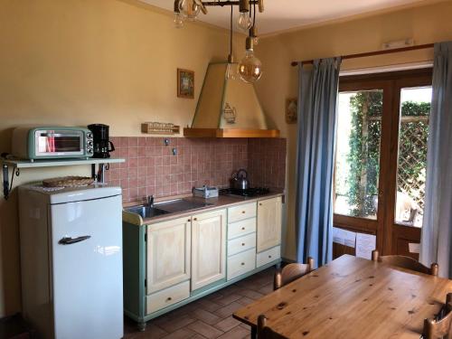 a kitchen with a white refrigerator and a table at Agriturismo Tenuta La Fratta in Bagni di Lucca