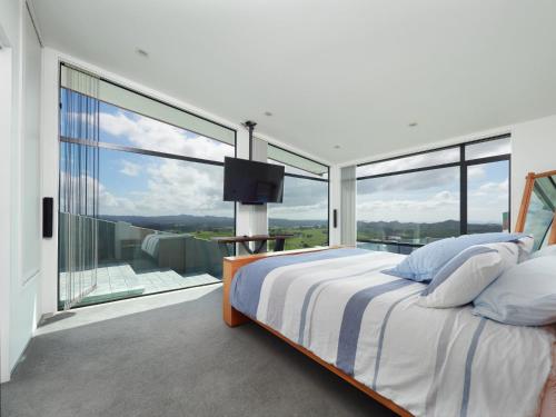 a bedroom with a bed and a large window at Parua Bay home with everything you'll need in Parua Bay