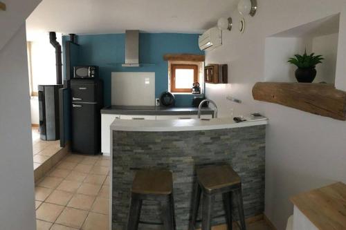 une cuisine avec un comptoir et des tabourets dans l'établissement Les Secrets de l'Isle, à La Roche