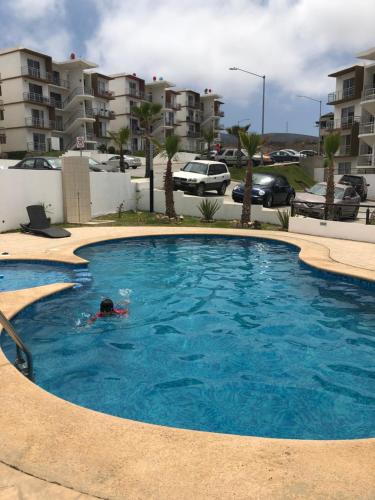 eine Person, die in einem großen Pool in einem Apartment schwimmt in der Unterkunft Condo Vacational in Ensenada, B.C. in Ensenada