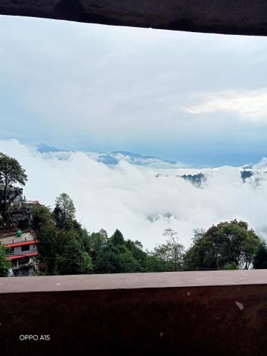a view of the clouds from the top of a mountain at Madys view -Aaple Ghar in Darjeeling