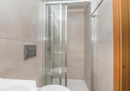 a shower with a glass door in a bathroom at Praia da Rocha Apartments in Portimão