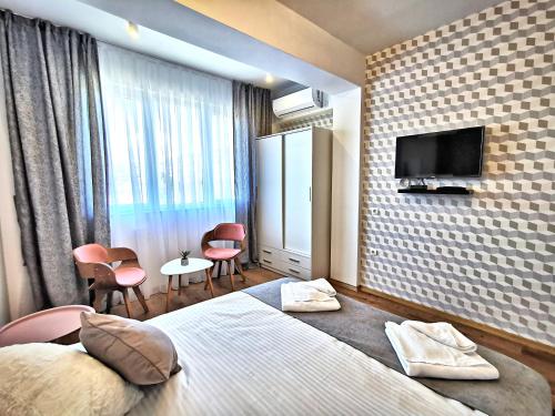 a hotel room with a bed and a tv at Guest rooms Denicija in Skopje