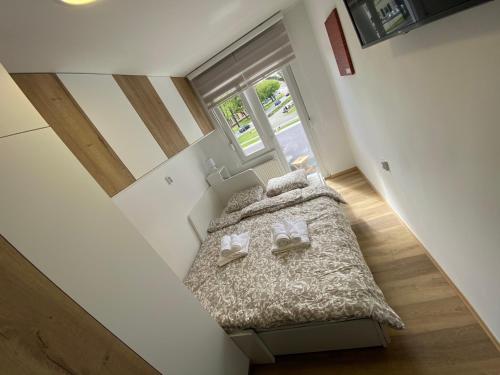 ein Schlafzimmer mit einem Bett in einem kleinen Zimmer in der Unterkunft Apartman Edita in Virovitica
