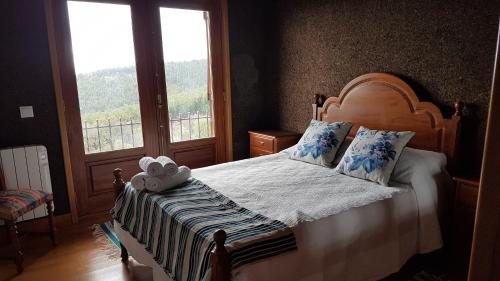 un lit avec un ours en peluche assis au-dessus dans l'établissement Casa da Cortiça, à Figueiró dos Vinhos