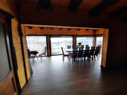 a dining room with a table and chairs and windows at Карпатский Рай in Yaremche