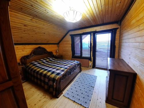 a bedroom with a bed in a wooden cabin at Карпатский Рай in Yaremche