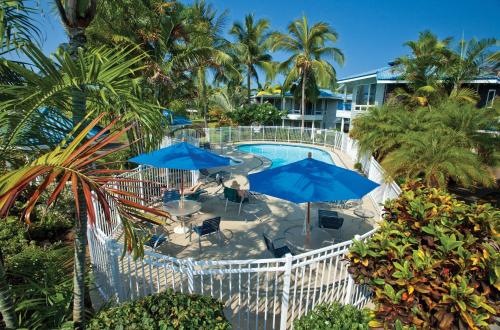 - une vue sur la piscine avec des parasols bleus dans l'établissement Wyndham Mauna Loa Village, à Kailua-Kona