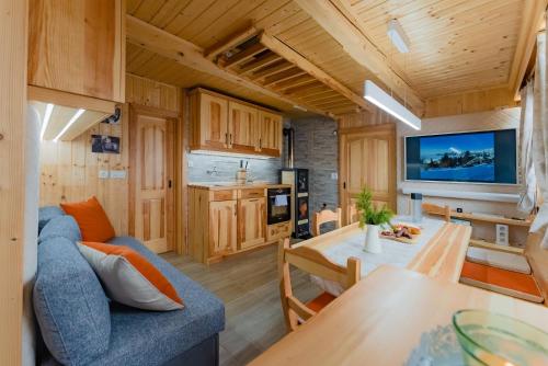 a living room with a blue couch and a table at Alpine Chalet Velika Planina - Irenca - I Feel Alps in Stahovica