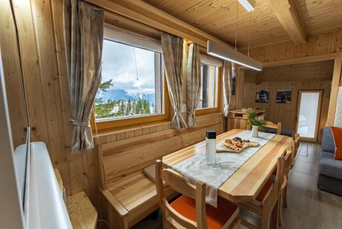a dining room with a wooden table and a tub at Alpine Chalet Velika Planina - Irenca - I Feel Alps in Stahovica
