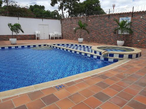 a swimming pool with blue water in a brick building at Hotel Fenix in Cúcuta